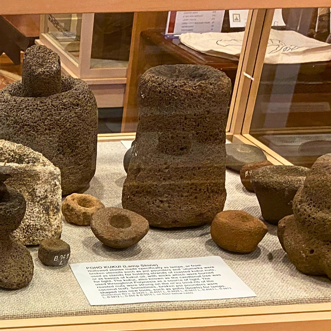 These are poho kukui, traditional Hawaiian stone lamps once used by our kūpuna to bring light into the darkness. Carefully hollowed from stone—sometimes repurposed from worn-out pōhaku ku‘i ‘ai (poi pounders)—they held strands of roasted kukui nuts or a small amount of kukui nut oil with a wick.
Like modern candles, they helped guide the way, both physically and spiritually. Each lamp tells a story of resourcefulness, mālama (care), and deep connection to the land.
Want to learn more about the tools and traditions of our ancestors? Come visit us at the museum. We’re open Monday through Friday from 11am to 3pm. 